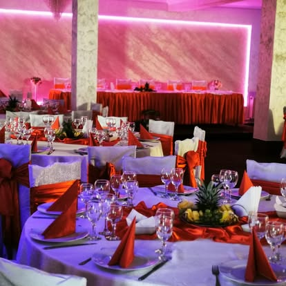 Salon decorat cu lumini ambientale și mese pentru nuntă